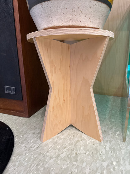 Wooden shelf with star-shaped cutout on a tiled floor