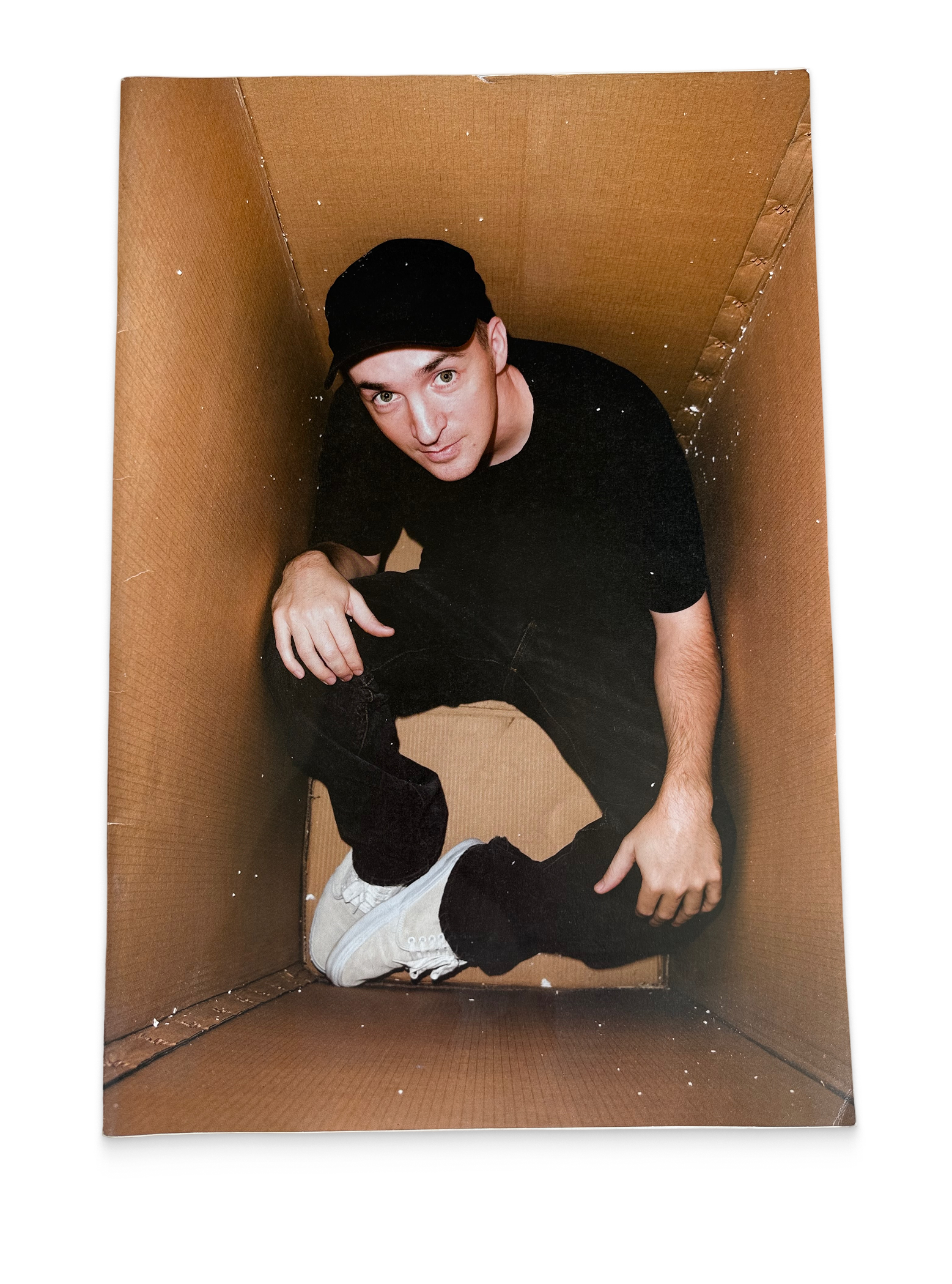 Person wearing a black outfit and cap inside a cardboard box on a white background, ANPQ Quarterly / RVCA, vintage magazine, front cover — Homeguts