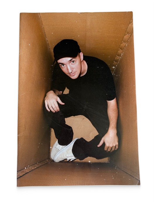 Person wearing a black outfit and cap inside a cardboard box on a white background, ANPQ Quarterly / RVCA, vintage magazine, front cover — Homeguts